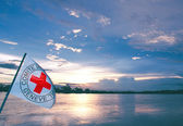 Foto: Eine Rotkreuzfahne an einem See.