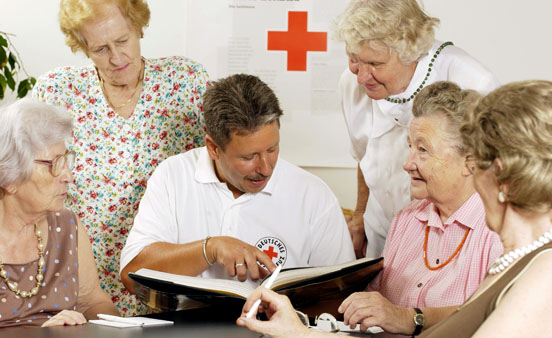 Foto: Pfleger und Seniorinnen beim Gedächtnistraining